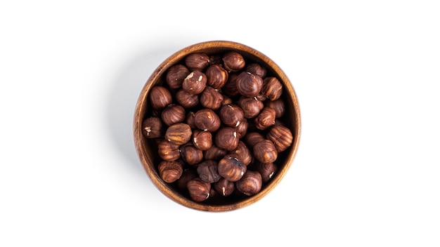 Hazelnut in a wooden bowl isolated on a white surface