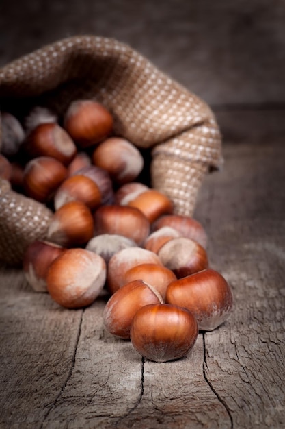 Hazelnuts in a bag on old wooden table