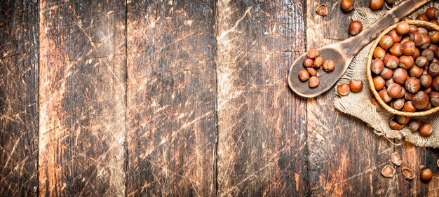 Hazelnuts in a basket on wooden background