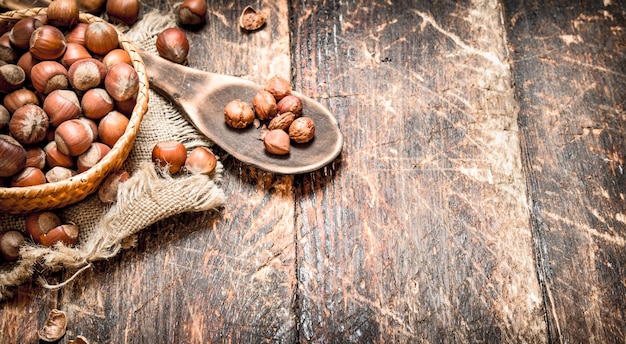 Hazelnuts in a basket. On wooden background.