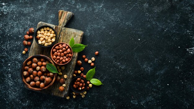 Hazelnuts in a bowl on a black stone background Nut free space for your text Top view