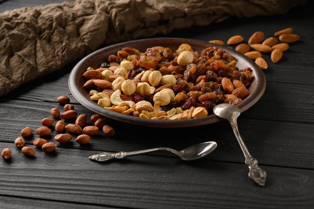 Hazelnuts cashews raisins almonds peanuts walnuts on a wooden black background