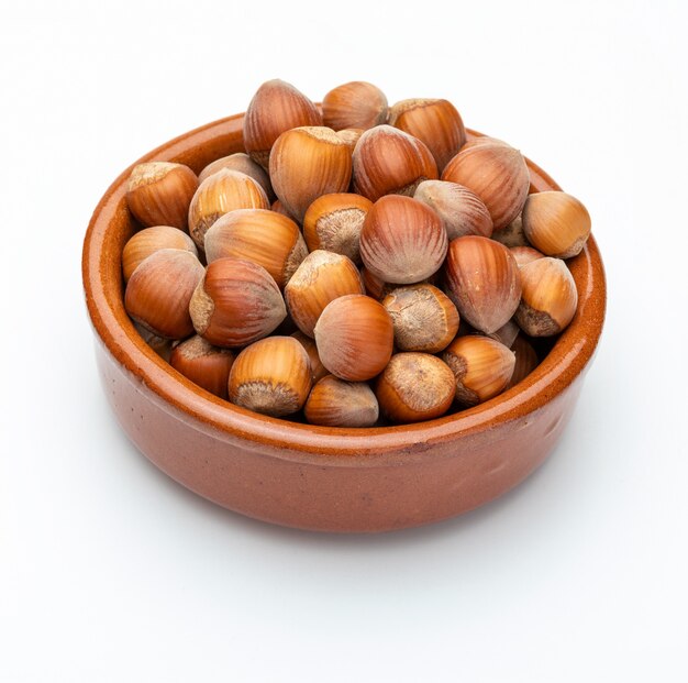 Hazelnuts in clay bowl (Various nuts collection). Isolated