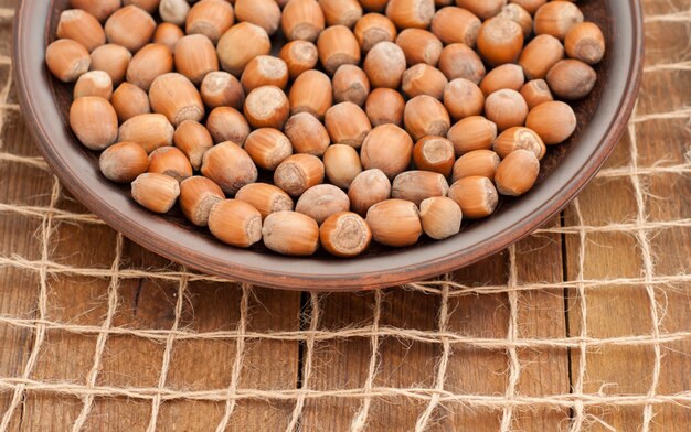 Hazelnuts closeup on a plate on wooden background