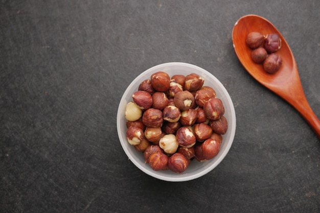 Hazelnuts in a container on black background