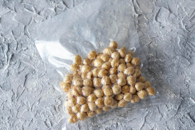 Hazelnuts in a plastic vacuum bag on a gray textured background