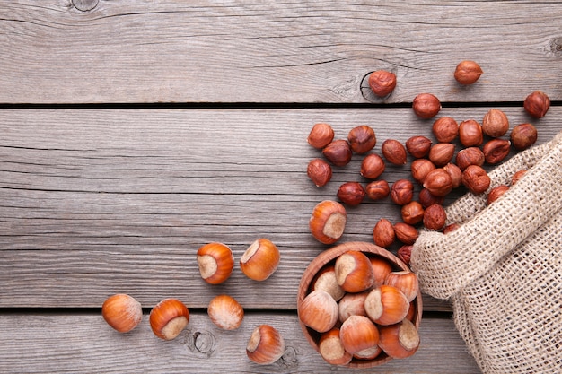 Hazelnuts in the sack and bawl on grey wooden table