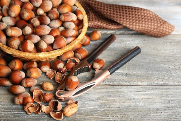 Hazelnuts in wicker basket on wooden background