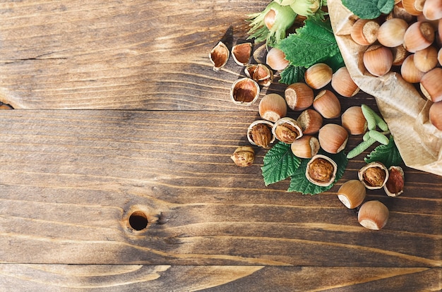 Hazelnuts with green leaves on a wooden surface