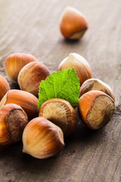 Hazelnuts with shell and green leaf on the wooden table