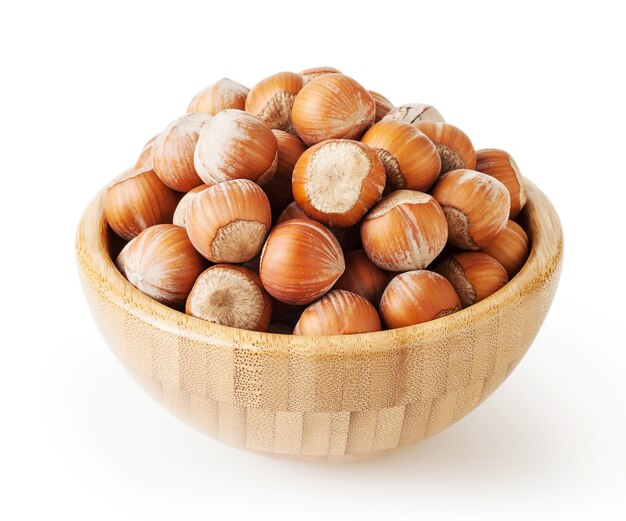 Hazelnuts in wooden bowl isolated on white background with clipping path