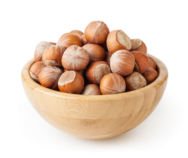 Hazelnuts in wooden bowl isolated on white background with clipping path