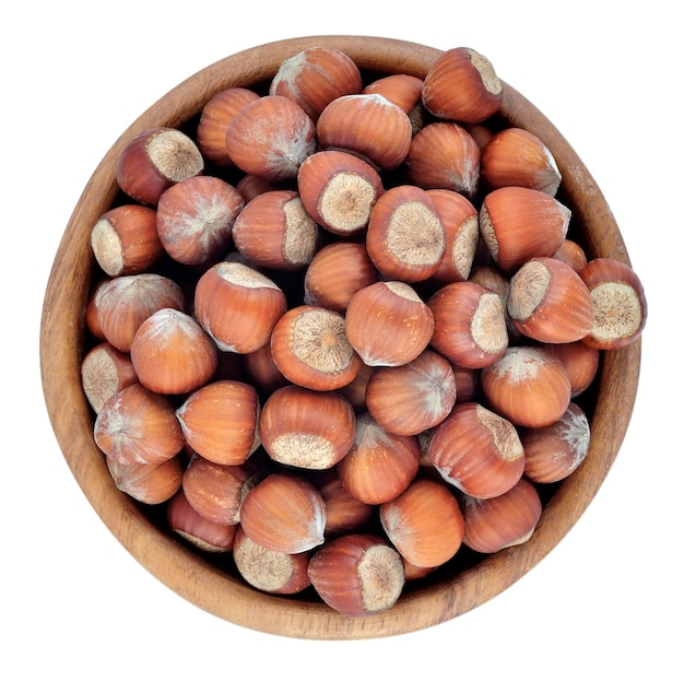 Hazelnuts in a wooden bowl on a white background