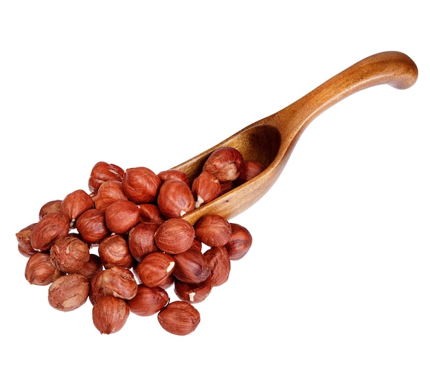 Hazelnuts in the wooden spoon isolated on white background