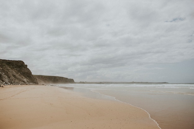 Hazy beach by a cliff