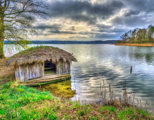 Photo hdr landscape with an old hut at the lake shore