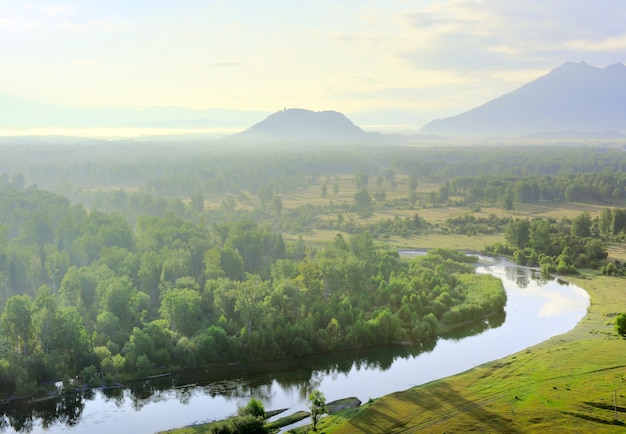 He bend of the river, the hills in the fog under the golden sky in the Altai mountains. Siberia, Russia