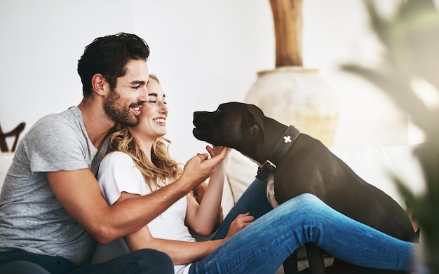 Photo he brings joy and laughter into our lives shot of a couple and their pet relaxing at home