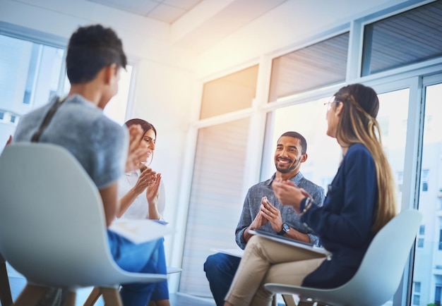 He deserves a round of applause Shot of a group of cheerful young businesspeople having a creative meeting at work