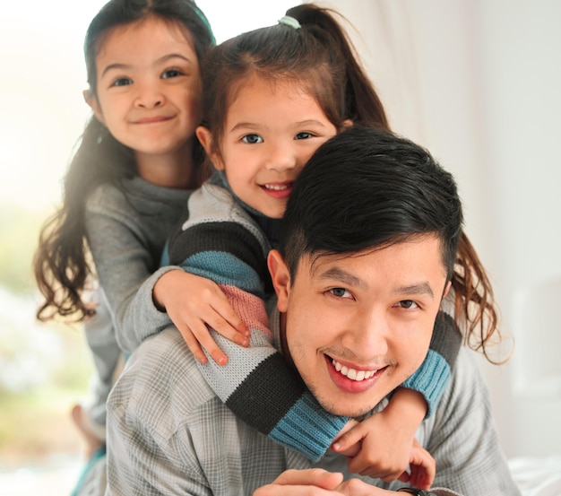 Он относится к воспитанию детей как полный и абсолютный босс. Снимок мужчины, проводящего время со своими двумя дочерьми дома.