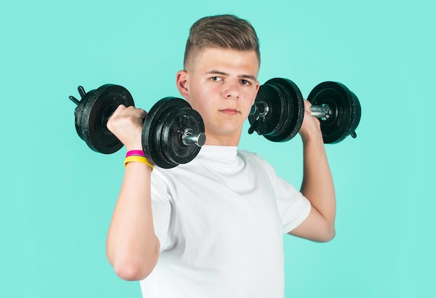 彼は、ダンベルの力と強度の重量挙げを備えたフィットネスの子供のトレーニングの強力なコンセプトです。