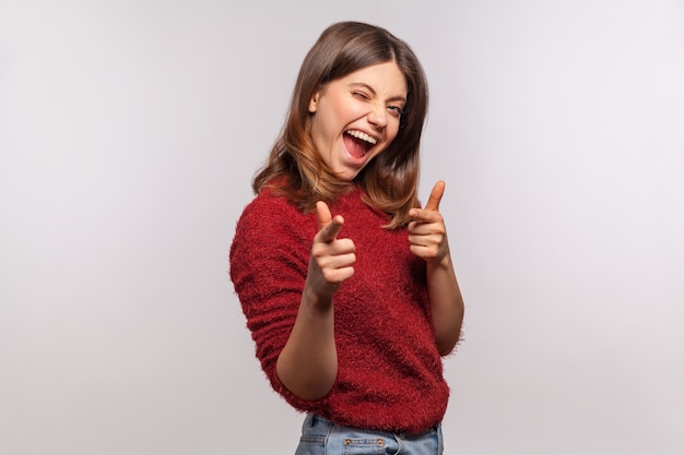 He jij! Portret van een speelse brunette vrouw die met de vinger naar de camera wijst, opgewonden glimlachend