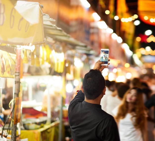 He just had to get a picture Rearview shot of a young man taking pictures while touring a foreign city