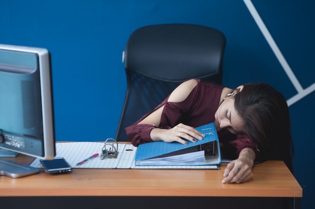 He office worker sleeps at the desk