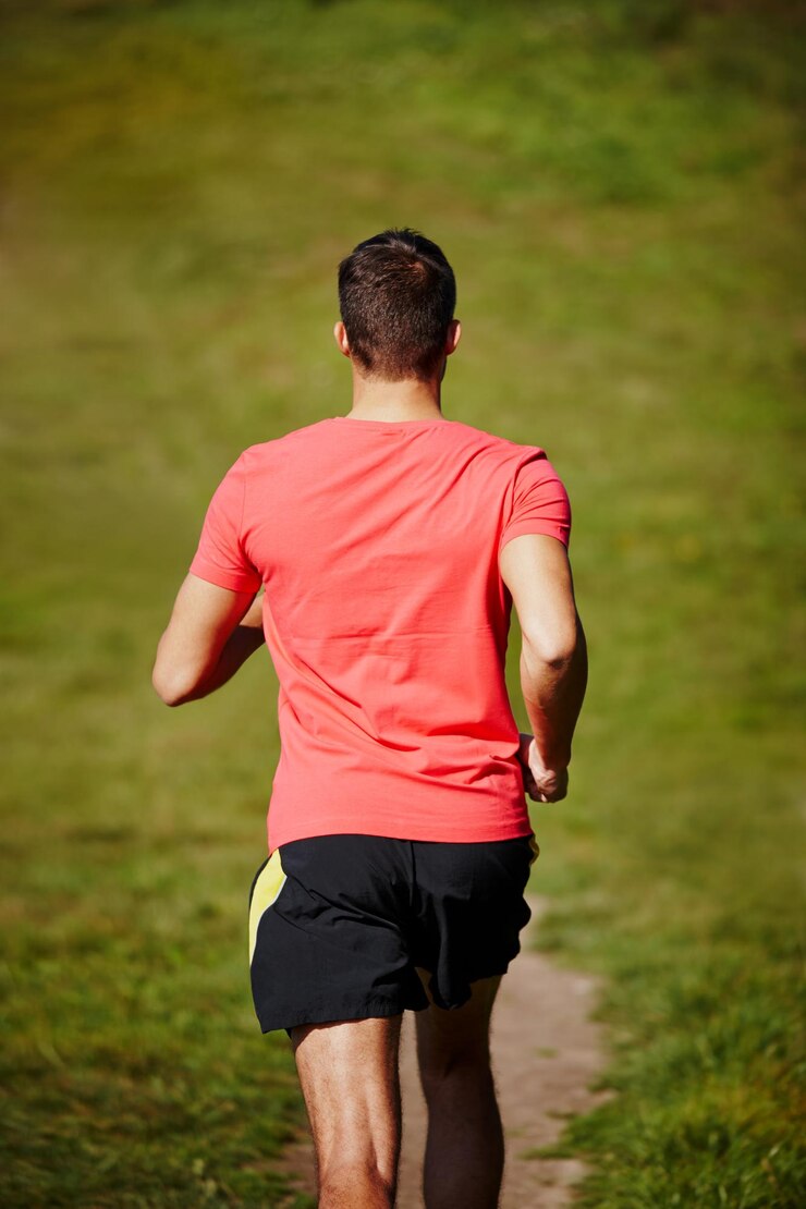 Photo he wont stop now high angle rearview shot of a young man running on an outdoor trail