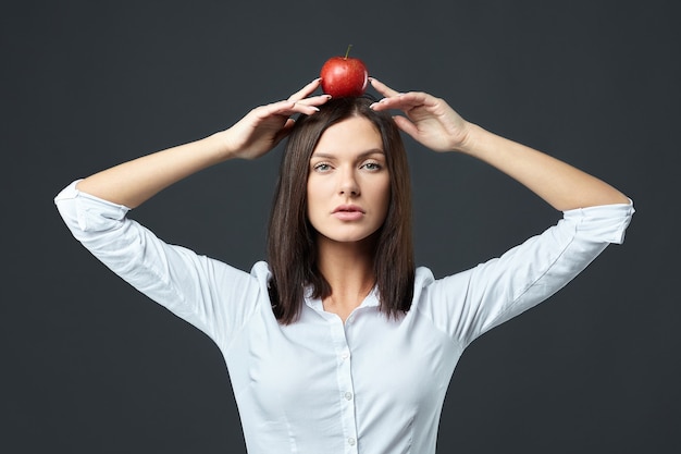 On the head of an attractive girl is a red Apple, symbolizing a target