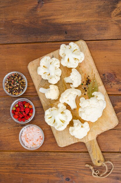 Head of cabbage fresh organic cauliflower on wooden background, spices. Studio Photo