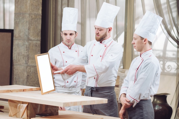 Head Chef and his staff in kitchen. interacting to  in commercial kitchen.