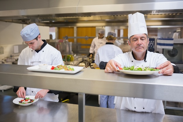 Head chef inspecting salad before service