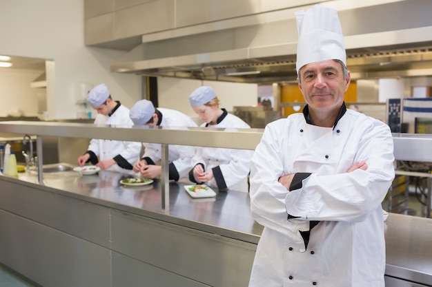 Head chef smiling in busy kitchen