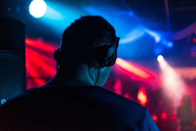 Head of DJ with headphones playing back event in night club music