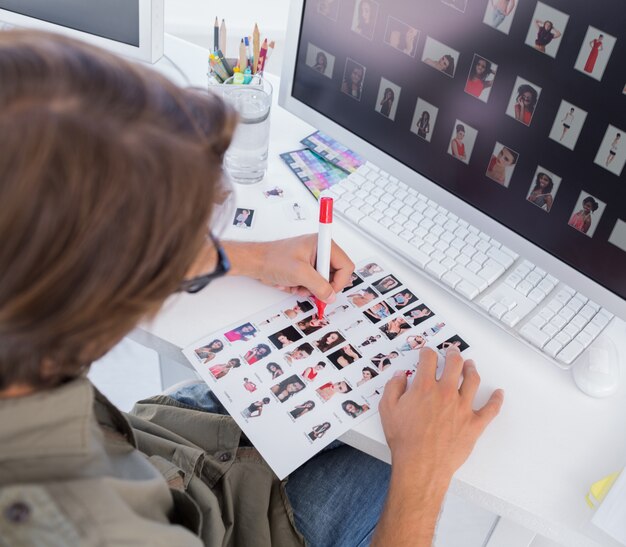 Photo over head of editor marking contact sheet