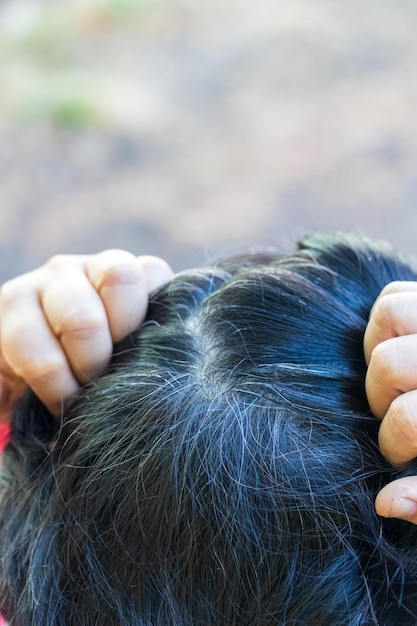 Testa di donna anziana dai capelli grigi che crescevano dopo la tintura