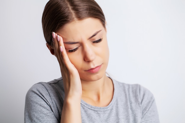 Head pain, exhausted young woman has suffering from unbearable headache