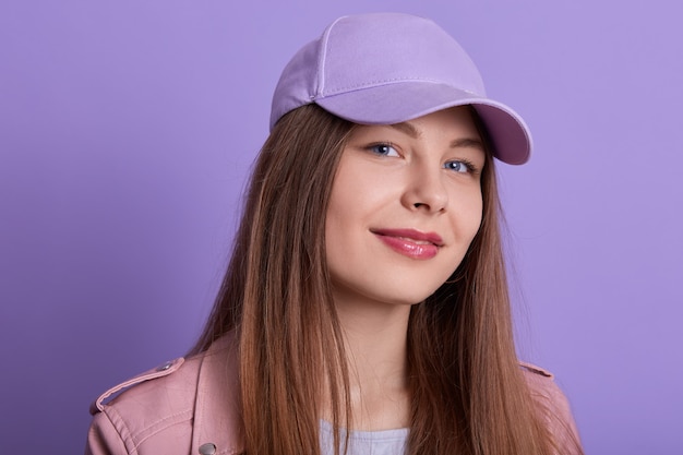 Head shot of attractive cute charming smiling Caucasian female wearing cap