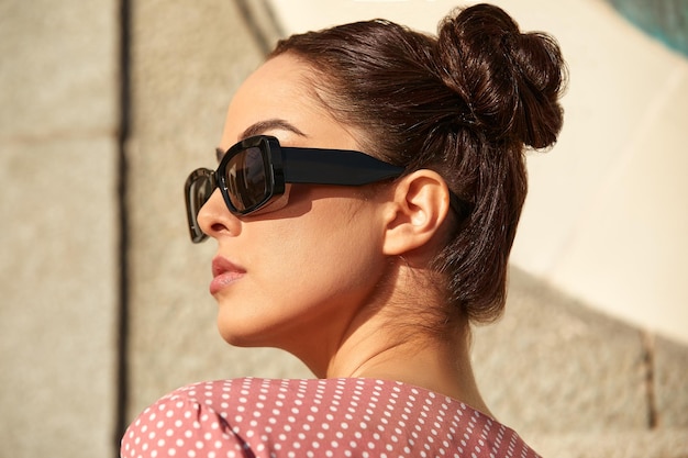 Head shot of beautiful brunette wearing glasses on the background of a stone wall Outdoors lifestyle portrait