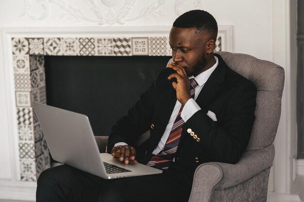 Head shot ernstige verbaasd Afro-Amerikaanse zakenman laptop scherm kijken