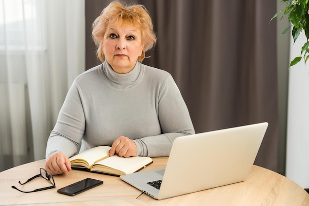 Head shot mature woman looking at camera and talking, grandmother chatting with relative online, making video call, middle aged blogger recording vlog, teacher speaking to webcam, distance lecture.