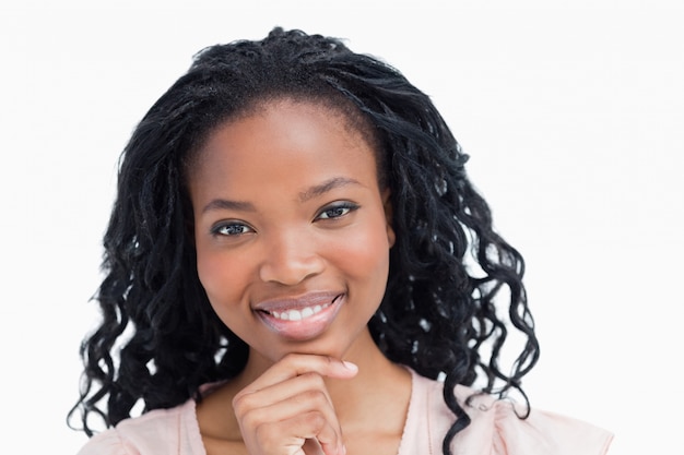 Head shot of a smiling young woman resting her head on her hand