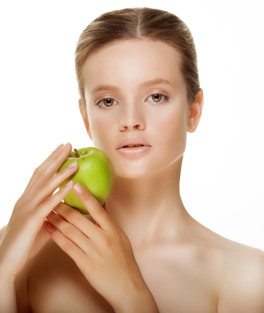 Head shot of woman holding green apple against white background