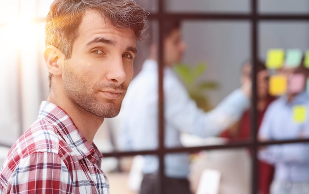 Head shot young attractive businessman standing in modern office pose for camera