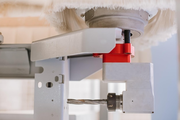 Head with a drill on a woodworking machine at a furniture factory