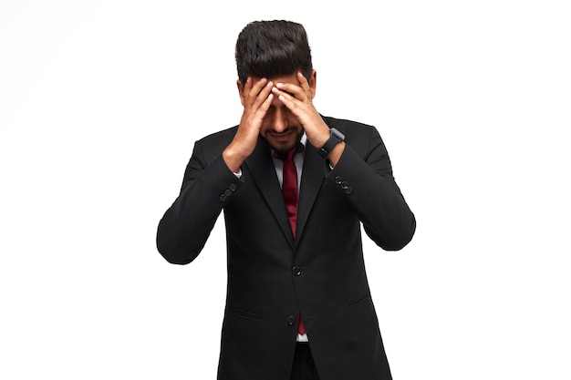 Photo headache of an indian business man in a suit on an isolated white background.