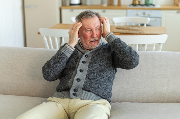 Боль в голове боль несчастный пожилой мужчина среднего возраста страдает от головной боли больной потирает храмы дома