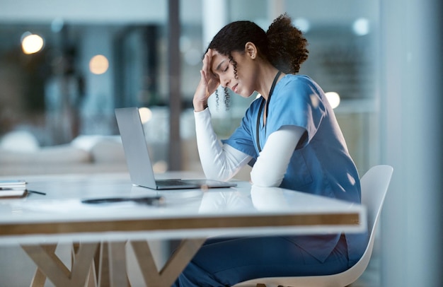 病院の頭痛ストレス看護師と黒人女性は、夜勤で痛みを感じ、疲れたり病気になったり、ラップトップで遅くまで働いている間に、うつ病や燃え尽き症候群のヘルスケア・ウェルネスや女性医師