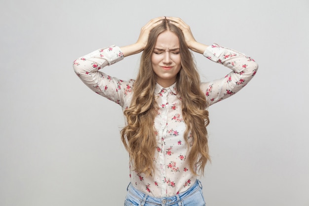 Headache unhappy blonde girl touching her head and have a migraine